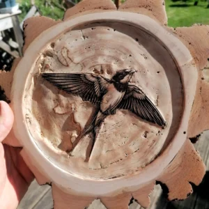 Hirondelle gravée en 3D en profondeur sur une tranche de bois brut, finition poncée à la main