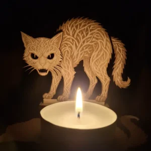 Photophore chat 2 d'Halloween ajouré en bois gravé au laser avec une bougie allumée projetant des ombres sur un mur.